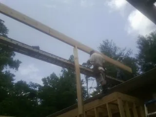 Carpenter setting a ridge beam over a new addition frame — Ice Dam Removal by Roofing Brothers in Chauncey