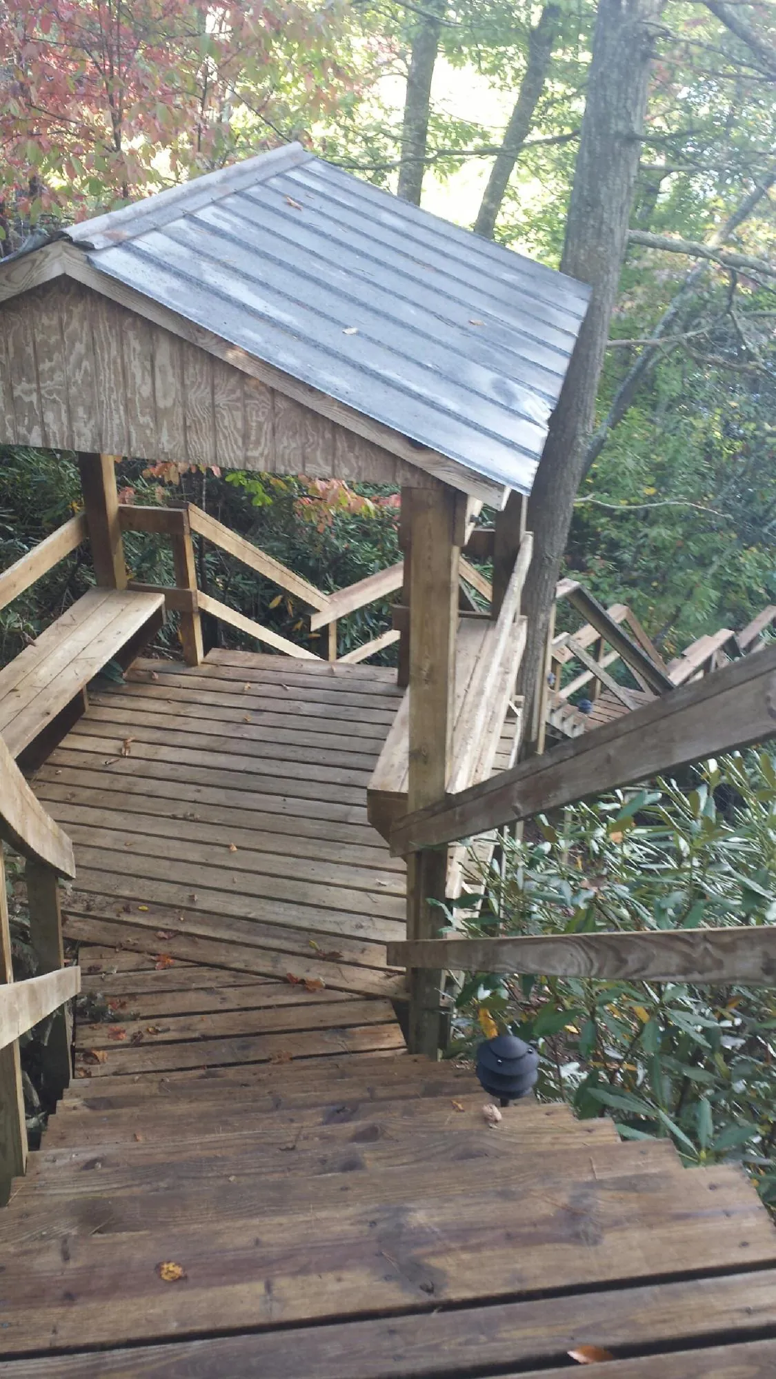 Metal roofed shelter over wooden steps on a wooded walkway — Skylight Repair & Installation work by our crew in Chauncey